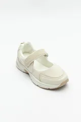 Zapatillas deportivas negras con suela blanca de 4cm de alto y tira ajustable con velcro.