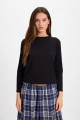 Remera de manga larga color blanco, con cuello redondo y corte holgado. Presenta un pequeño bordado en el centro del pecho.