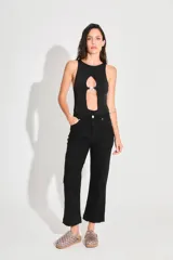 Body negro de seda fría con escote cerrado y abertura en el delantero unida por un aplique metálico con el logo de la marca.