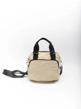 Bolso pequeño color beige con diseño acolchado, doble asa de mano negra y correa larga negra desmontable y regulable.