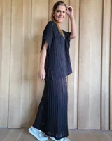 Pantalón de punto calado color crudo, de corte palazzo y cintura elástica.