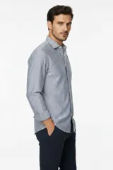 Camisa de algodón de manga larga con diseño de rayas verticales en tonos gris y blanco, cuello camisero clásico y cierre frontal con botones.