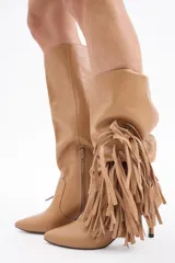 Bota de caña alta confeccionada en cuero vacuno color bordó, con diseño de flecos laterales y taco fino.