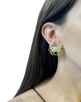 Aros dorados con forma de cangrejo, con incrustaciones de circonitas blancas y ojos de circonita negra.