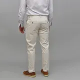 Pantalón de gabardina color azul marino, de corte ajustado y tiro medio, con cierre y botón frontal.