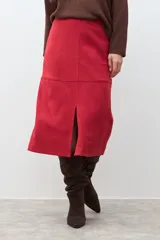 Falda midi roja de simil gamuza, con corte recto y tajo frontal.