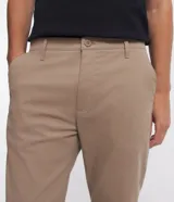 Pantalón de corte slim y estilo cropped, confeccionado en tejido plano de algodón con un toque de elastano. Presenta cierre frontal con botón y cremallera, trabillas para cinturón y bolsillos laterales y traseros.