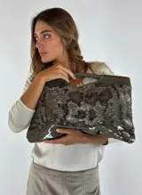 Bolso de mano tipo clutch color azul con lentejuelas negras.