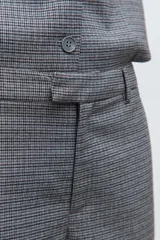 Pantalón sastrero de corte recto y tiro medio, confeccionado en tela con estampado de microcuadros en tonos grises. Presenta bolsillos laterales y cierre frontal con botón.