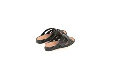 Sandalias planas Denu color negro, confeccionadas a mano en cuero con textura suave y diseño de tiras cruzadas en el empeine. Cuentan con plantilla anatómica y suela flexible de poliuretano.