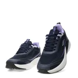 Championes deportivos Umbro modelo Vex, color azul marino con detalles en violeta y blanco. Presentan una capellada de malla transpirable, cierre con cordones y una entresuela blanca con refuerzo estructural oscuro en el talón.