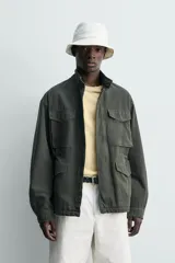 Cazadora regular fit de algodón color gris oscuro con efecto lavado, cuello subido, manga larga y cierre frontal con cremallera oculta por solapa con botones a presión. Cuenta con cuatro bolsillos frontales de plastrón con solapa y cintura ajustable con cordón interior.
