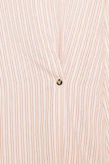 Camisa de corte oversize con estampado de rayas verticales, cuello subido y cierre frontal con botones. Presenta mangas largas con puños y un diseño cruzado en la parte delantera.