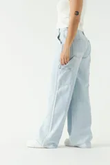 Pantalón jean de tiro medio color celeste claro, corte ancho y estilo carpenter.