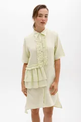 Vestido camisero color ladrillo con cuello, cartera y volados frontales y laterales en lino color lima. De calce relajado y mangas cortas.