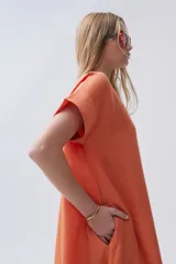 Vestido midi azul de lino, corte recto, escote en V, mangas cortas, bolsillos laterales y tajos laterales. Incluye un pañuelo estampado atado a la cintura.