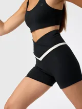 Short deportivo negro de talle alto con cintura cruzada en forma de V y detalle de ribete en contraste beige.