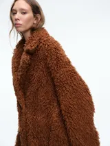 Tapado de textura tipo peluche en color marrón, con solapas anchas, mangas largas y corte holgado.