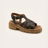 Sandalias de cuero vacuno negro con textura símil cocodrilo, diseño de tiras cruzadas, suela track de goma y hebilla metálica de ajuste en el tobillo.