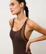 Enterito deportivo corto de microfibra seamless Get Over, color marrón oscuro con franjas laterales en tono tostado y textura acanalada. Presenta diseño ajustado, escote redondeado y tirantes finos cruzados en la espalda.