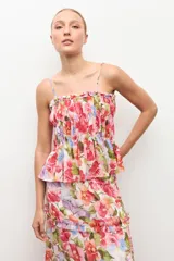 Top de tirantes finos con escote recto y detalle fruncido con elástico en el pecho. Presenta diseño con volados escalonados y estampado floral color rosado.