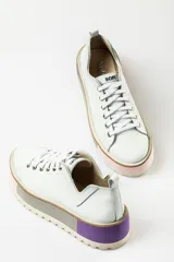 Zapatillas deportivas color marrón con cordones, suela gruesa con detalles en celeste y gris.