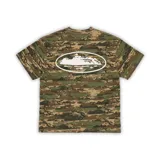 Remera de manga corta con estampado de camuflaje digital en tonos verdes y marrones. Presenta un gráfico central en color blanco dentro de un óvalo que representa una isla.