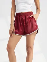 Short deportivo de satén color bordó con cintura elástica y ribetes blancos en los bordes.