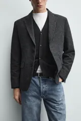 Blazer regular fit de bouclé con diseño pata de gallo en tonos oscuros, solapas de muesca, cierre de un botón y bolsillos con solapa en la cadera.