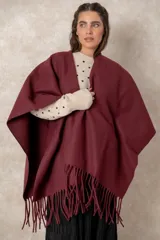 Ruana abierta de color beige, confeccionada en tejido de punto con terminación de flecos en el ruedo.