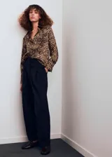Camisa de tejido satinado con estampado de leopardo, corte recto, manga larga con puños abotonados, cuello camisero y cierre delantero con botones.