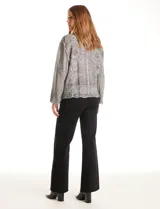 Camisa de algodón color gris con bordados florales en el frente y las mangas. Tiene cuello con solapa y cierre frontal con botones.