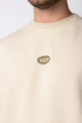 Buzo de cuello redondo y corte oversize, confeccionado en frisa suave. Presenta un diseño minimalista en color negro con un pequeño logo ovalado en el centro del pecho y una estampa sutil en el lateral inferior derecho.