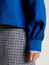 Camisa azul con cuello mao, corte cropped, mangas largas abullonadas con puño y cierre frontal con botones. Confeccionada en mezcla de modal ligera con acabado texturizado.