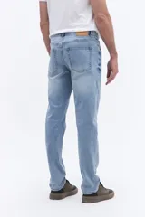 Jean de corte recto y tiro medio con efecto lavado, confeccionado en tejido de algodón con elastano. Presenta cierre frontal con botón y cremallera, bolsillos laterales y traseros, y trabillas para cinturón.