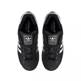 Championes adidas modelo Superstar, de diseño clásico con exterior de cuero negro, las icónicas tres tiras laterales en blanco y puntera de goma reforzada.