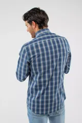 Camisa de manga larga con diseño de cuadros en tonos azules, blancos y negros. Presenta cuello clásico, cierre frontal con botones y logo bordado en el pecho. Corte semi slim.