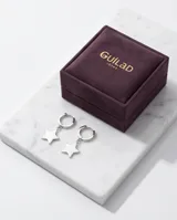 Aros tipo argolla pequeña de plata con dije colgante en forma de estrella.