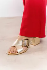 Sandalia color beige con tiras cruzadas y hebilla metálica cuadrada. Taco cuadrado de 6 cm.