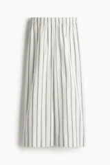 Pantalón de corte holgado y tiro alto, confeccionado en algodón con diseño a rayas verticales. Presenta piernas amplias de largo tobillero, cintura elástica y bolsillos laterales.