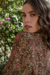 Camisa negra con estampado de flores y palmeras en tonos beige y rojo.