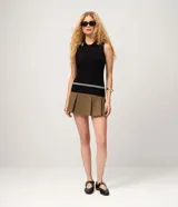 Blusa celeste sin mangas confeccionada en punto, con cuello polo, detalles contrastantes a rayas blancas en el cuello y cierre frontal parcial con botones.