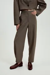 Pantalón de tiro medio con estampado de cuadros pequeños, bolsillos laterales y cierre frontal con cremallera y gancho metálico.