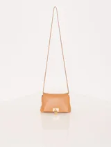 Bandolera pequeña de cuero color marrón, con correa larga regulable para usar al hombro o cruzada. Cierre con imanes ocultos y aplique metálico dorado en forma de candado. Interior forrado con dos divisiones y bolsillo con tarjetero.