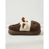 Pantuflas de peluche con diseño de vaca, confeccionadas en piel sintética suave. Cuentan con suela de goma antideslizante y diseño abierto en el talón.