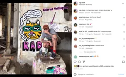 Remera blanca de algodón con estampa en la espalda de un gato amarillo con anteojos de sol fumando un cigarrillo y la palabra "RAD" en rosa.