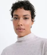 Camisón largo de tejido de punto color gris claro, con cuello alto y mangas largas. Tiene aberturas laterales.