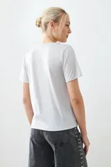 Remera de manga corta con cuello redondo y bolsillo frontal, confeccionada en tejido con acabado de lurex.