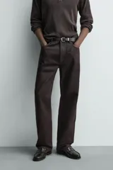 Jeans flare fit de denim negro, con tiro medio, corte ajustado en la parte superior y ligeramente acampanado desde la rodilla. Diseño de cinco bolsillos y cierre frontal con botones.