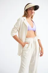 Visera de estilo clásico en color beige, con ala ancha y borde contrastante en color negro. Cuenta con una banda elástica posterior para un ajuste cómodo.